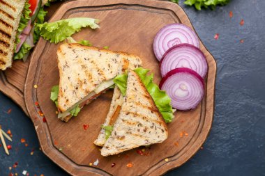 Koyu arkaplanda lezzetli sandviçler olan tahta