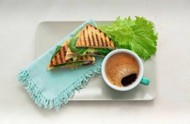 Lezzetli sandviçler ve açık arkaplanda bir fincan kahve.