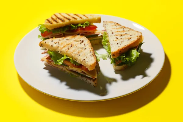 色の背景においしいサンドイッチとプレート クローズアップ — ストック写真