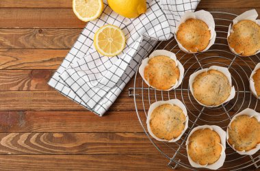 Ahşap arka planda lezzetli haşhaşlı çöreklerle soğutma ızgarası.