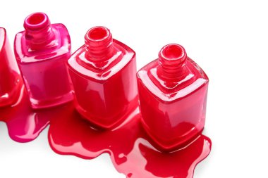 Açılmış şişeler ve beyaz arka planda dökülmüş ojeler.