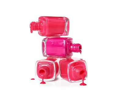 Beyaz arka planda tırnak cilası olan bir yığın şişe.