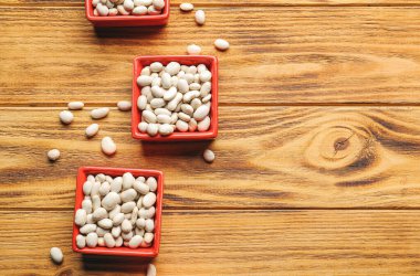 Ahşap arka planda çiğ fasulye kaseleri