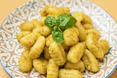 Masada lezzetli pesto gnocchi tabağı, yakın plan.