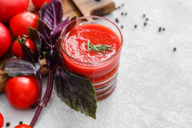 Hafif arka planda bir bardak lezzetli domates suyu.