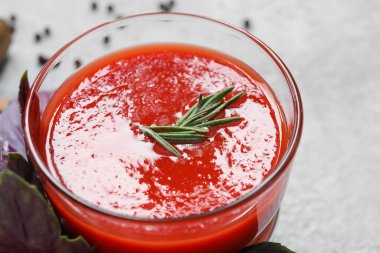 Hafif arka planda bir bardak lezzetli domates suyu.