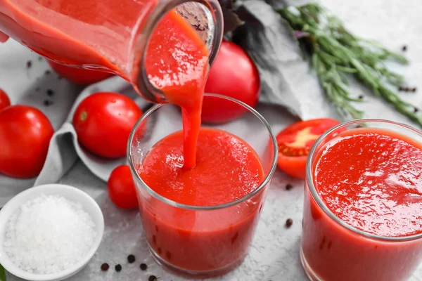 Gießen Leckeren Tomatensaft Aus Der Flasche Glas Auf Hellem Hintergrund — Stockfoto