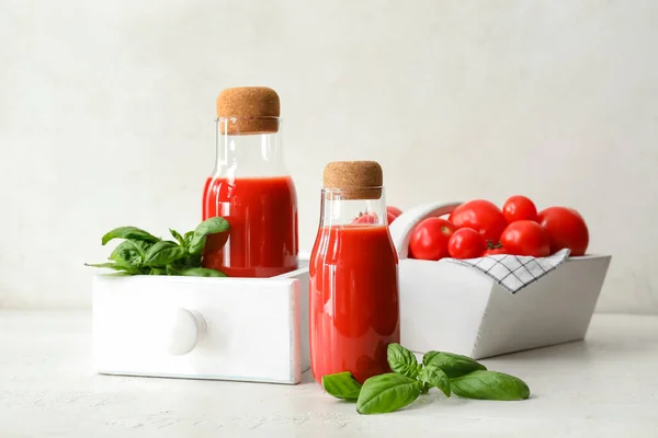 Flaschen Mit Leckerem Tomatensaft Auf Hellem Hintergrund — Stockfoto