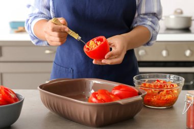 Mutfakta doldurulmuş domates hazırlayan kadın, yakın plan.