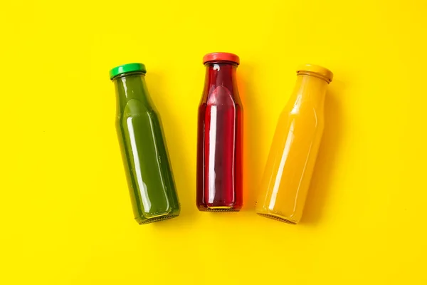 stock image Bottles with healthy juice on color background