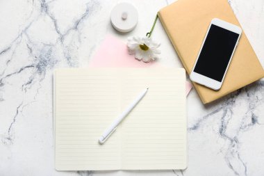 Hafif arkaplanda dizüstü bilgisayar, kalem ve cep telefonu ile kompozisyon