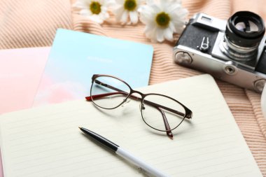 Not defterleri, gözlükler ve fotoğraf makinesi olan kompozisyon, yakın plan.