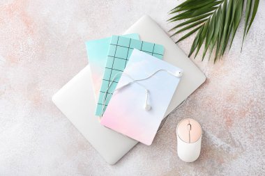 Grunge arka planında dizüstü bilgisayar, not defteri, kulaklık ve bilgisayar faresi olan kompozisyon