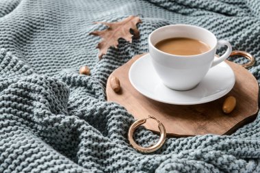 Bir fincan kahve, meşe palamudu ve ekoseli küpe.