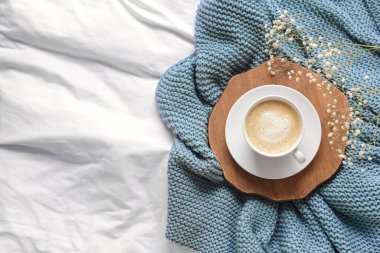 Ekoseli çiçekli bir fincan kahve.