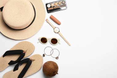 Beyaz arka planda kadın aksesuarları, kozmetik ürünleri ve hindistan cevizi.