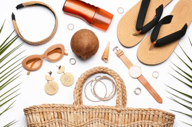 Beyaz arka planda plaj aksesuarları, güneş kremi ve hindistan cevizi.