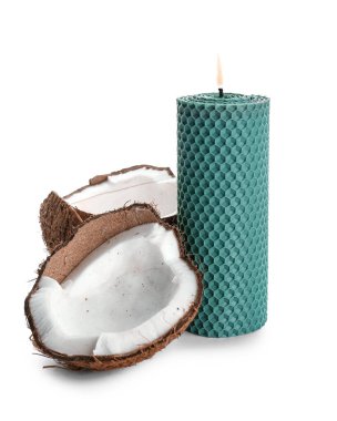 Yanan mum ve beyaz arka planda çatlak hindistan cevizi.