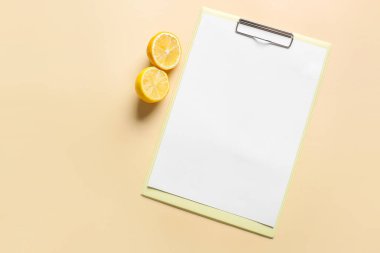 Renk arkaplanı üzerinde boş kağıt ve limon olan pano