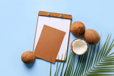 Renk arkaplan üzerinde boş kart, pano ve olgun hindistan cevizi bileşimi