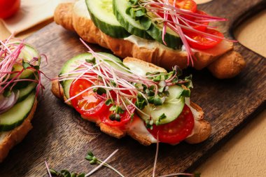 Sebzeli lezzetli kruvasanlar ve arka planda mikro yeşil, yakın plan.