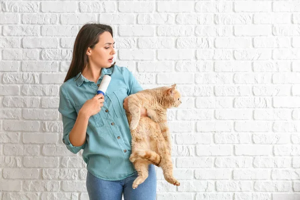 Upset Young Woman Cute Cat Lint Roller Brick Background — Stock Photo, Image