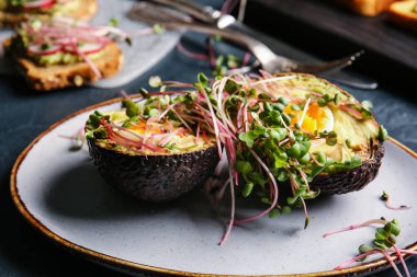 Lezzetli doldurulmuş avokado ve mikro yeşil tabaklar, yakın plan.