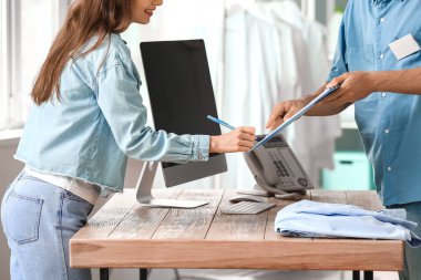 Modern kuru temizlemeciden sipariş alan erkek işçi.