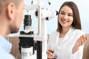 Oftalmolog klinikteki adamı muayene ediyor.