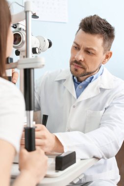 Klinikteki kadını muayene eden oftalmolog.