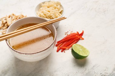 Bir kase lezzetli Tayland çorbası ve hafif arka planda malzemeler.