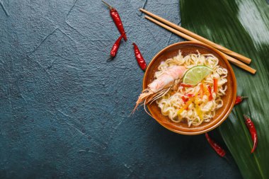 Koyu arkaplanda karidesli bir tay çorbası.