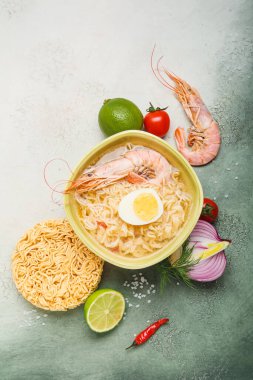 Bir kase lezzetli Tayland çorbası. İçinde karides ve malzemeler var.