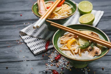 Koyu ahşap arka planda bir kase lezzetli Tayland çorbası.