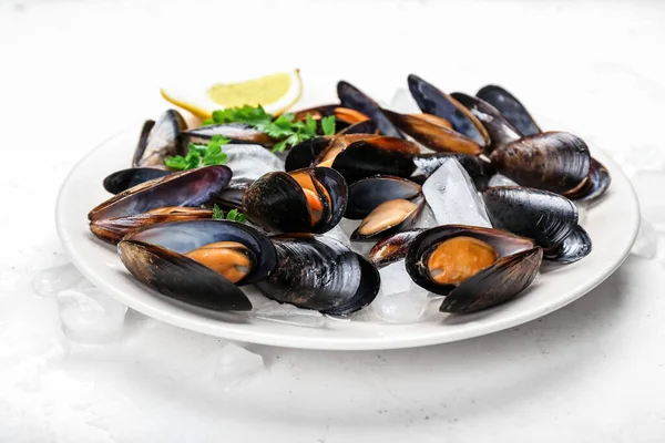 Hafif arka planda çiğ midye tabağı