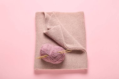 Örgü iğneli iplik ve renkli arka planda ekose kumaş