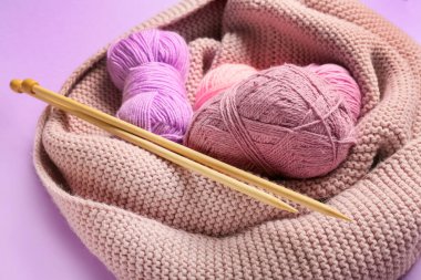 Renk arkaplanında iplik ve örgü iğneleri, yakın plan