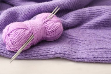 Örgü iğneli iplik ve beyaz masada ekose kumaş