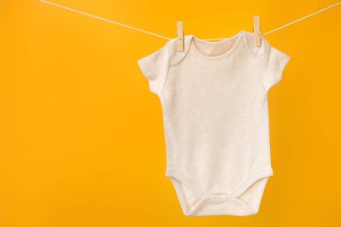 Bebek kıyafetleri renk arkaplanında ipte sallanıyor
