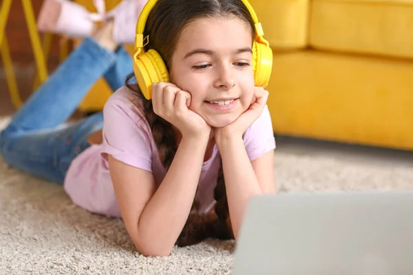 Cute girl watching cartoons at home