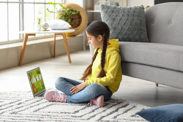 Cute girl watching cartoons at home