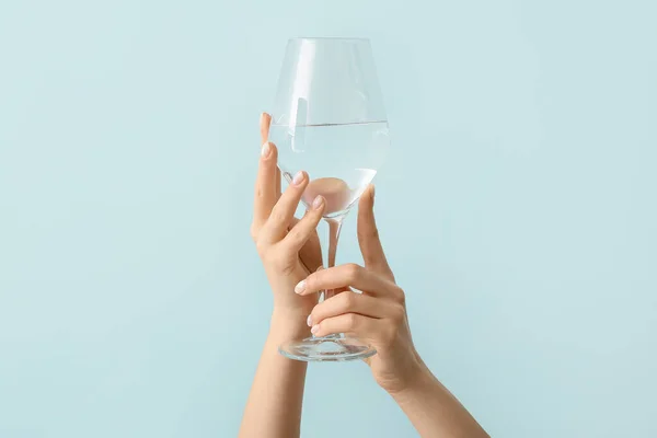 Frau Mit Schöner Maniküre Hält Glas Wasser Auf Farbigem Hintergrund — Stockfoto