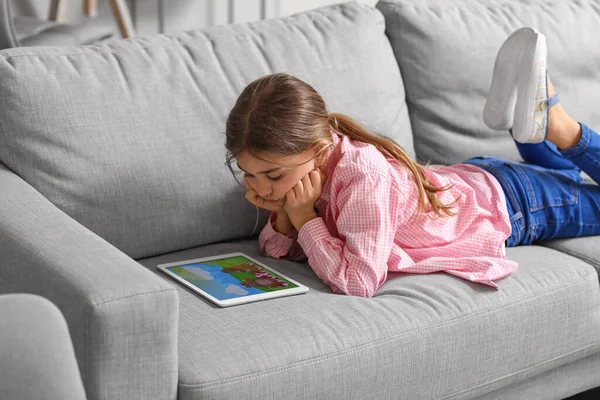 Cute girl watching cartoons at home