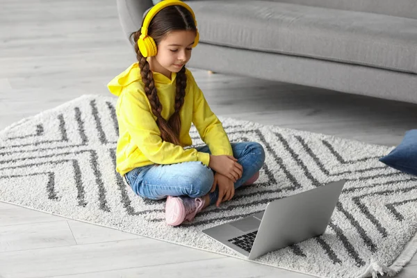 Cute girl watching cartoons at home