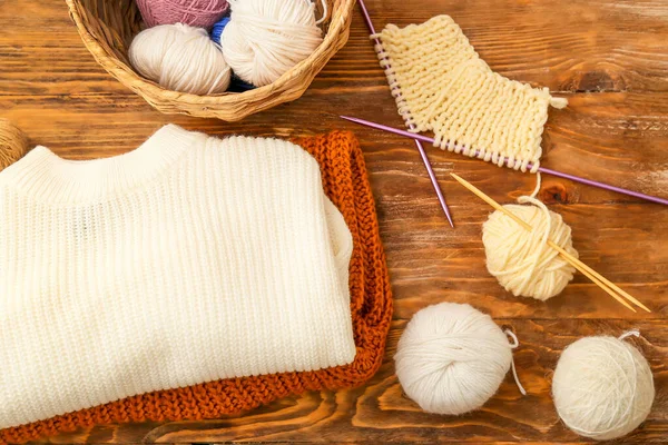 編み針 木製の背景のセーター — ストック写真