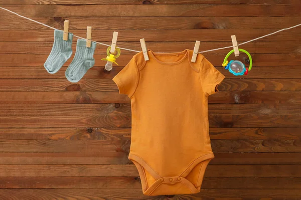 Baby Kläder Napphållare Och Leksak Hängande Rep Mot Trä Bakgrund — Stockfoto