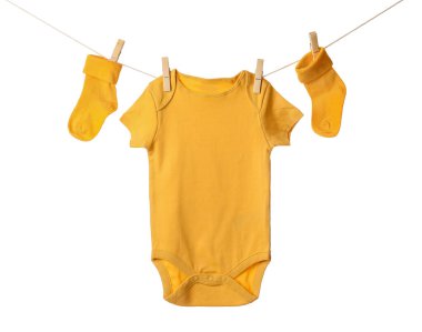 Beyaz arka planda bebek kıyafetleri asılı.