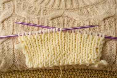 Bitmemiş elbiseli örgü iğneleri, yakın plan.