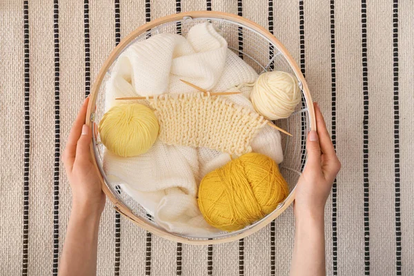 毛糸を編んだ籠を持つ女性 カーペットの上の針や服 — ストック写真