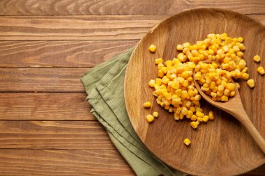 Tahta zemin üzerinde mısır taneleri olan plaka